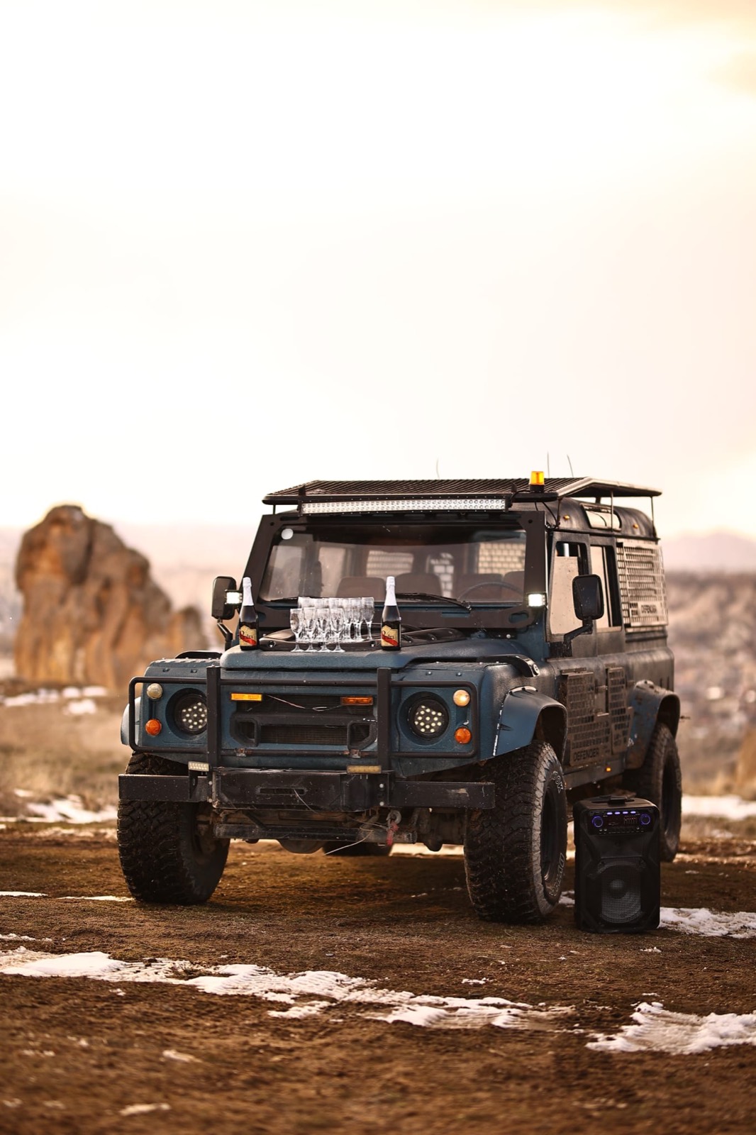 Sunset toast on the hood of a Defender